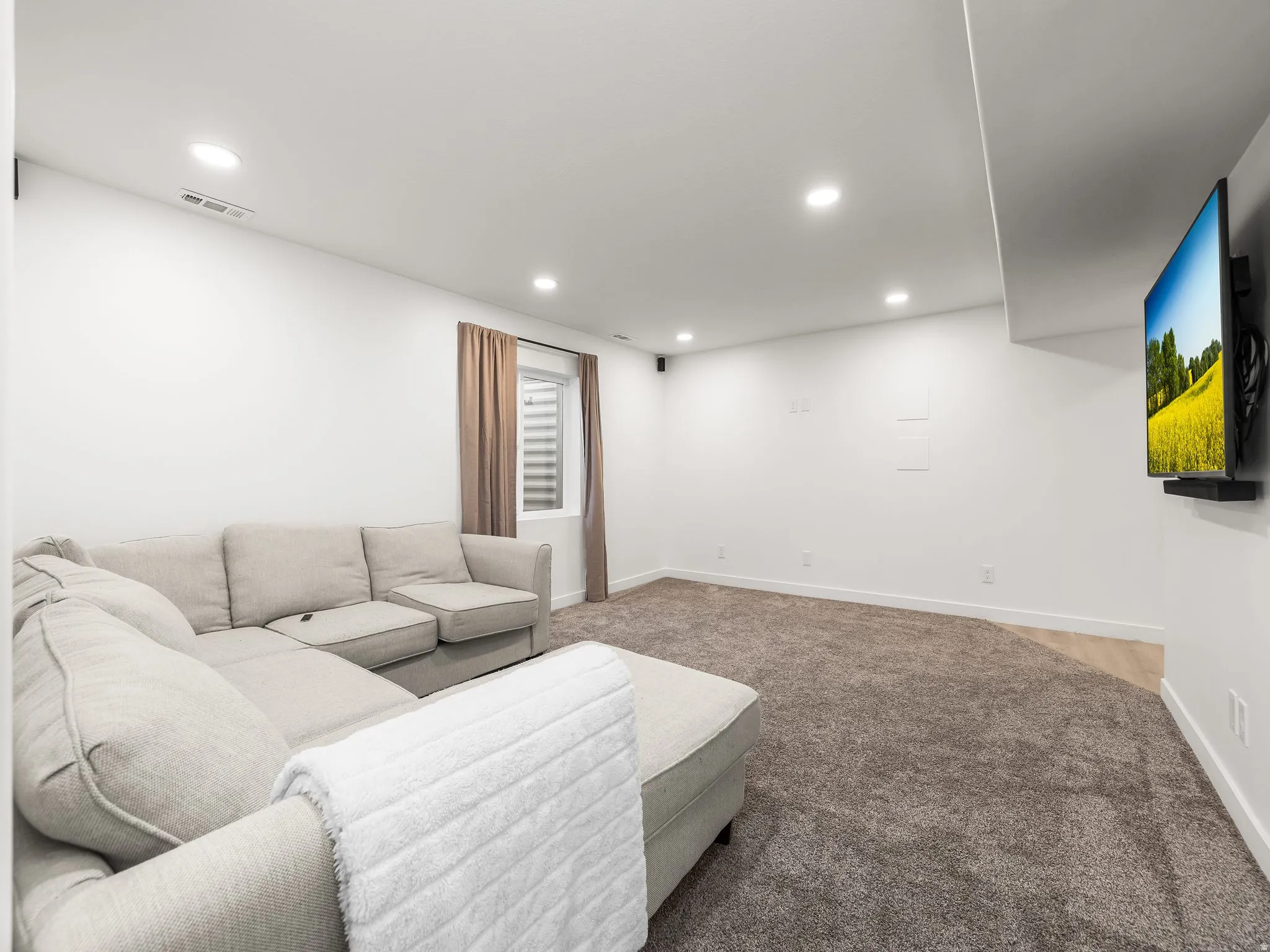 Living room with recessed lighting and light colored carpet