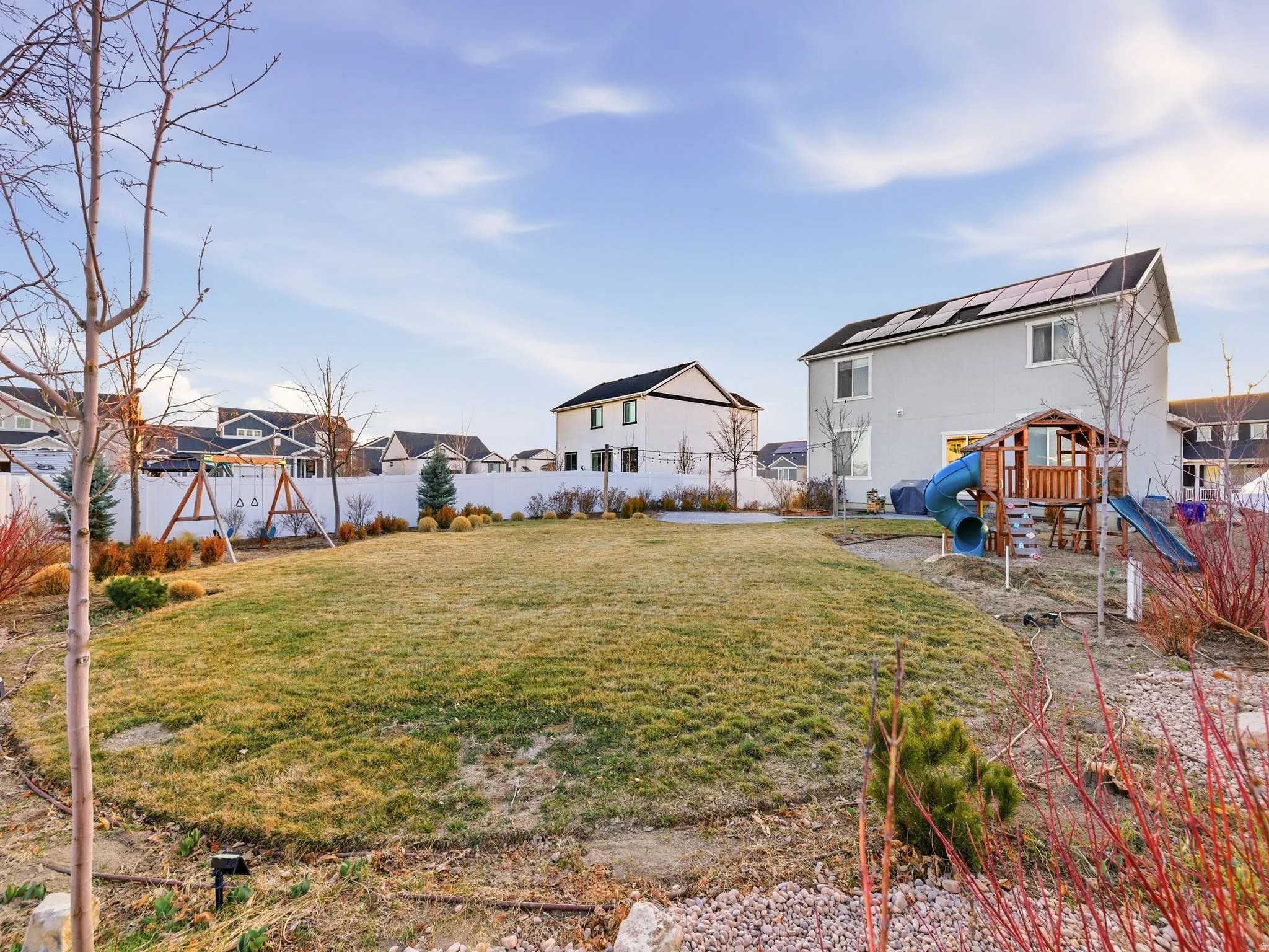 Fenced backyard with a playground and a residential view
