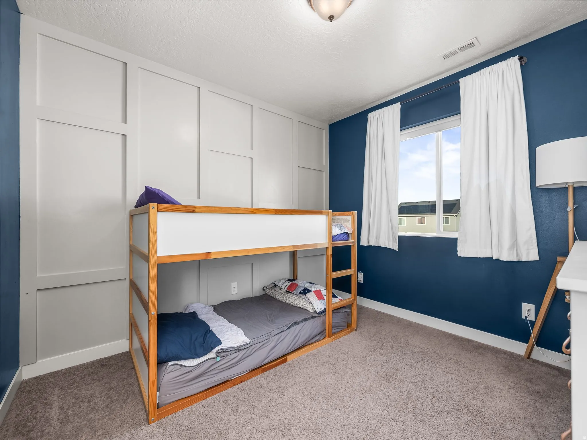 Carpeted bedroom featuring baseboards and a textured ceiling