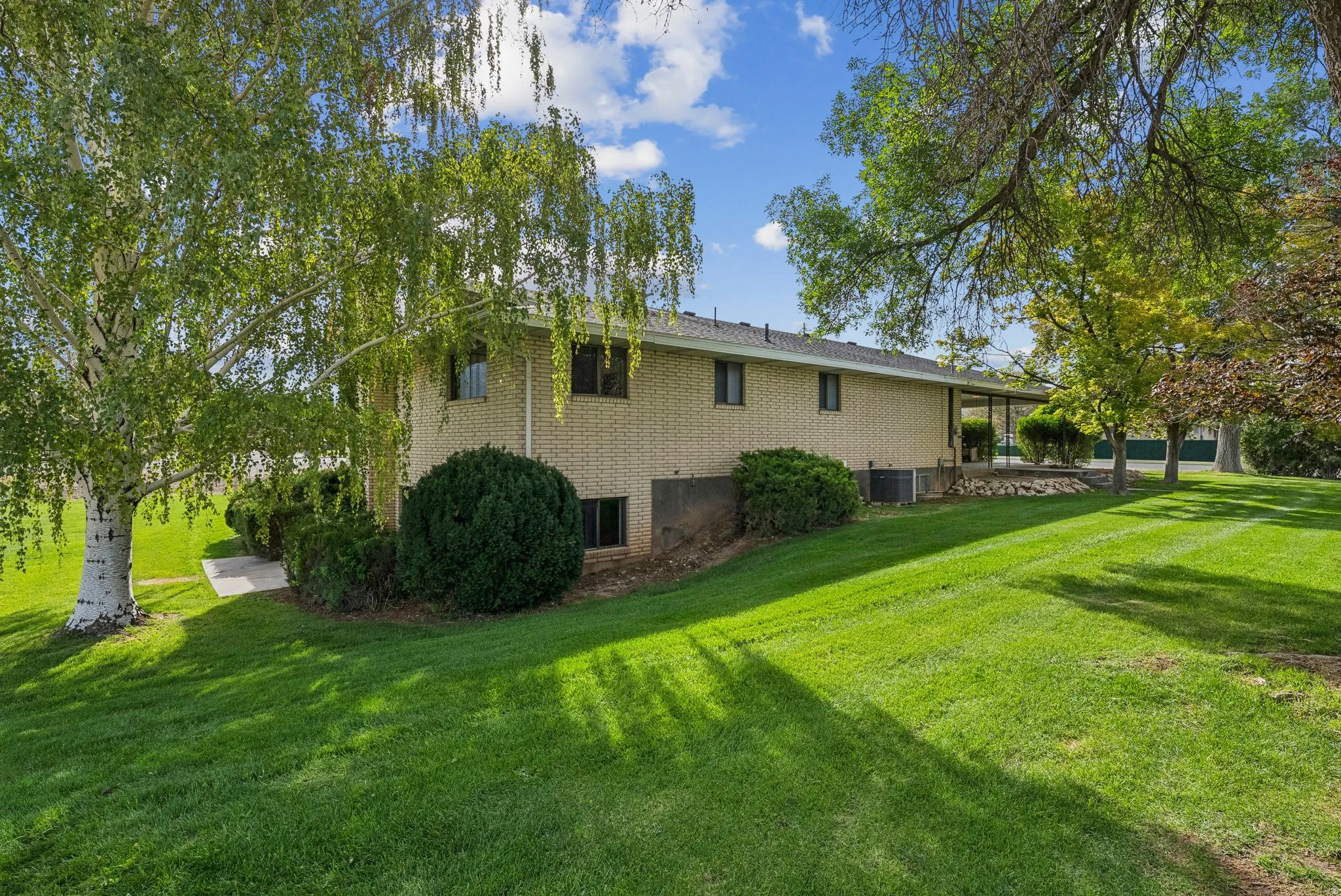 View of side of home featuring a lawn and brick siding