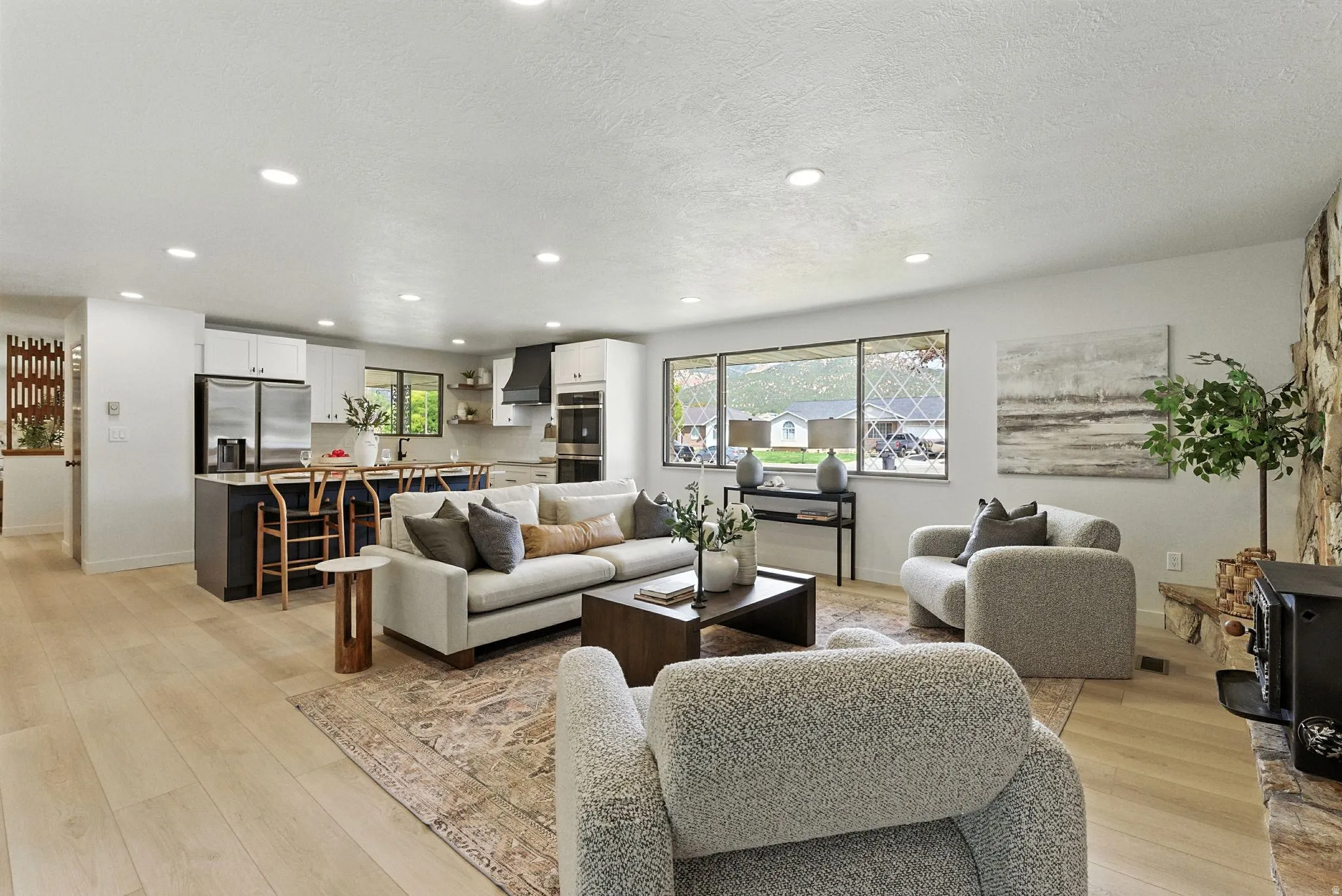 Living room with light wood-type flooring, recessed lighting, and a textured ceiling