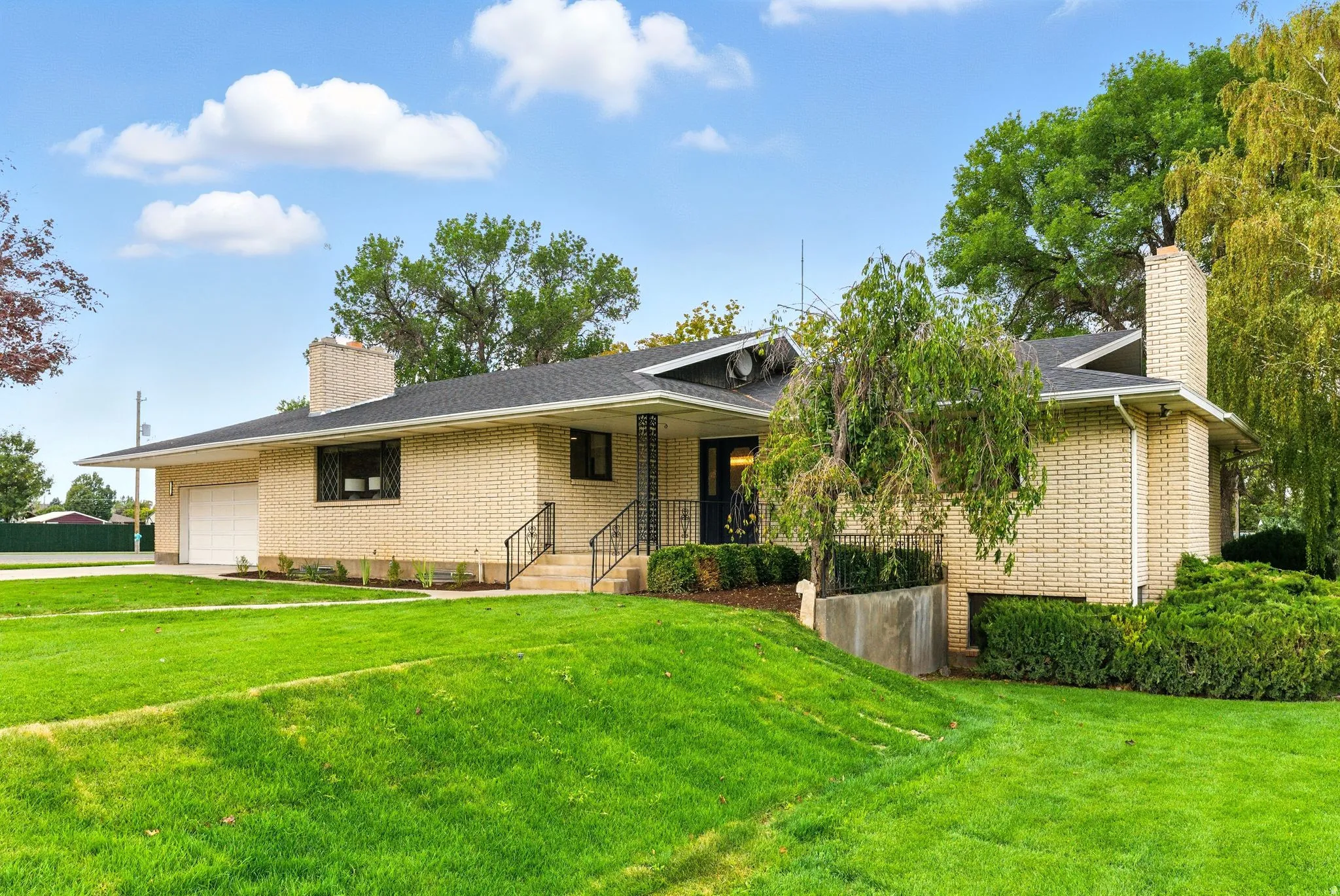 View of front of property with a chimney, a front yard, and an attached garage