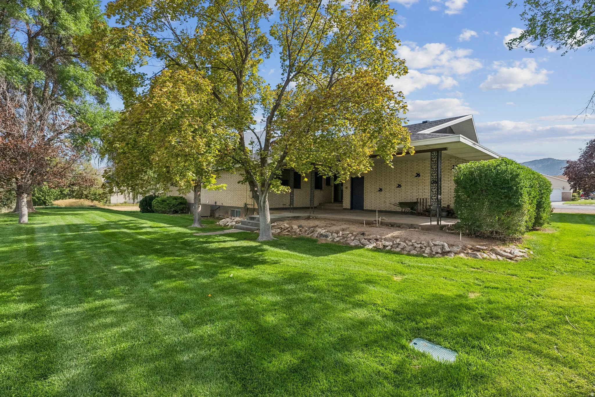 Rear view of property with a patio area, a lawn, and brick siding