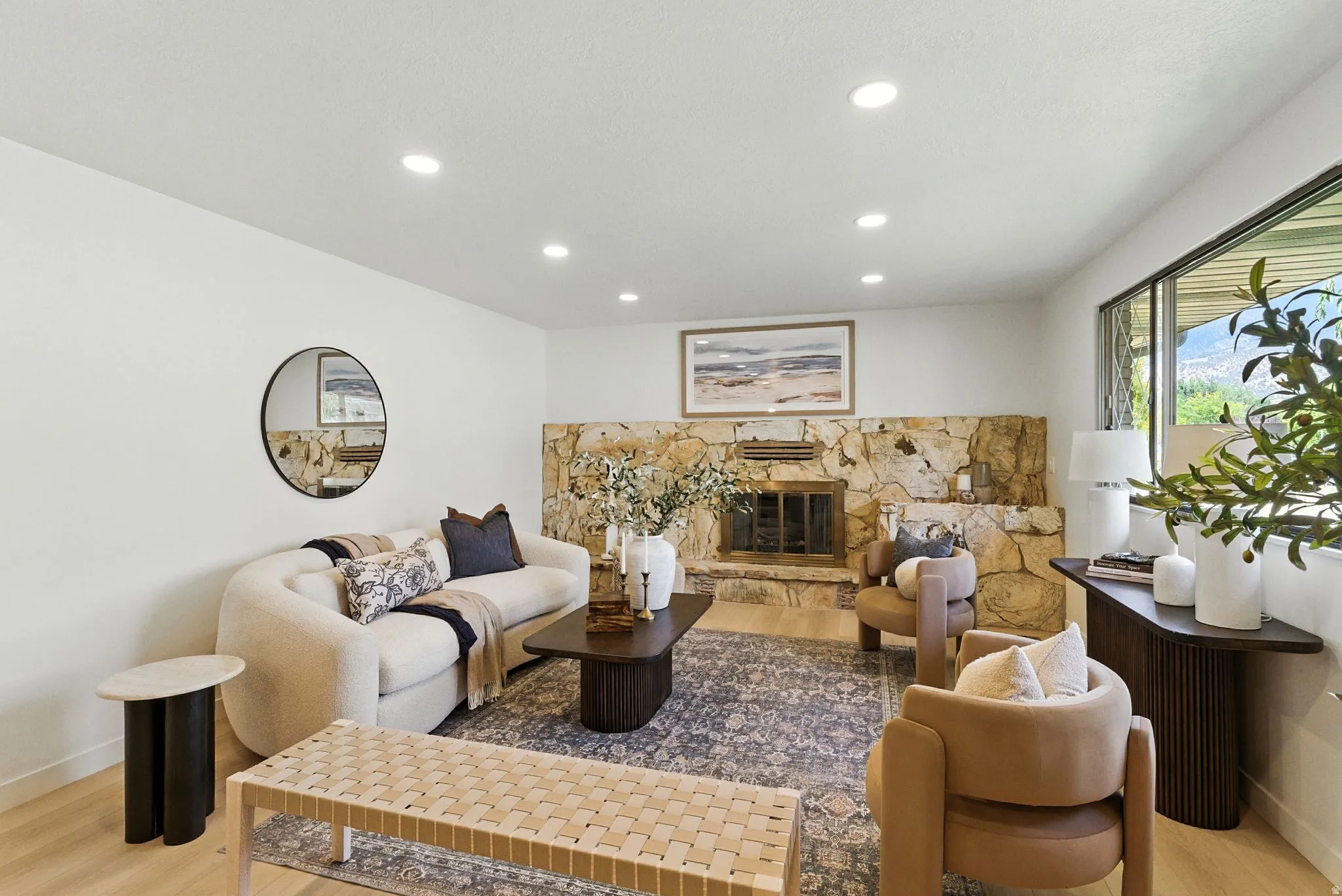 Living area with a fireplace, light wood-style floors, and recessed lighting