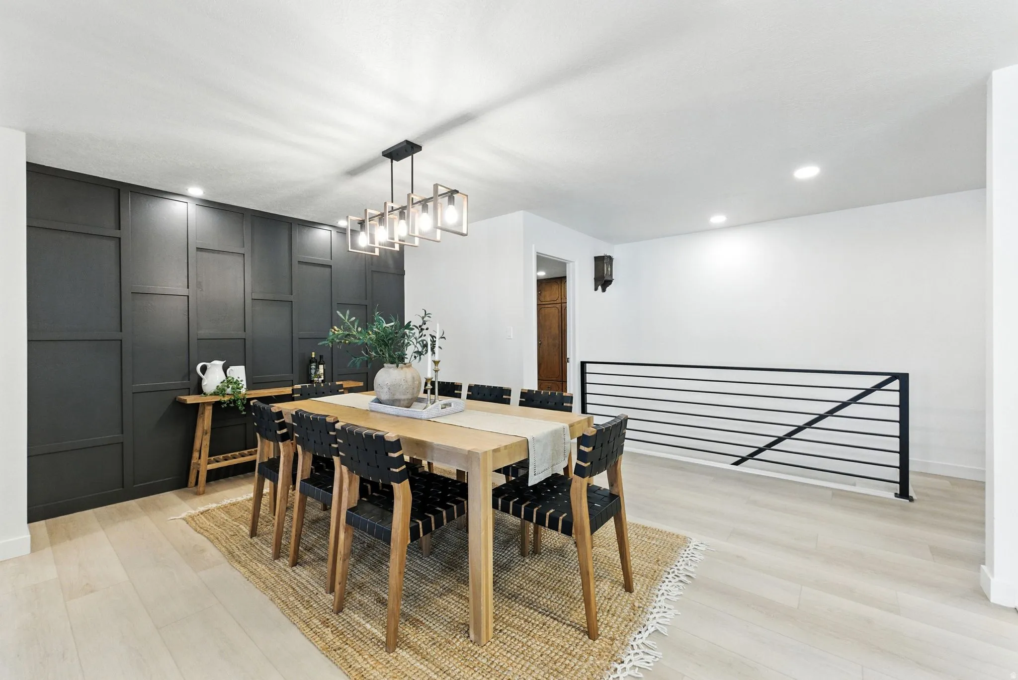 Dining room with light wood-type flooring, recessed lighting, and a decorative wall
