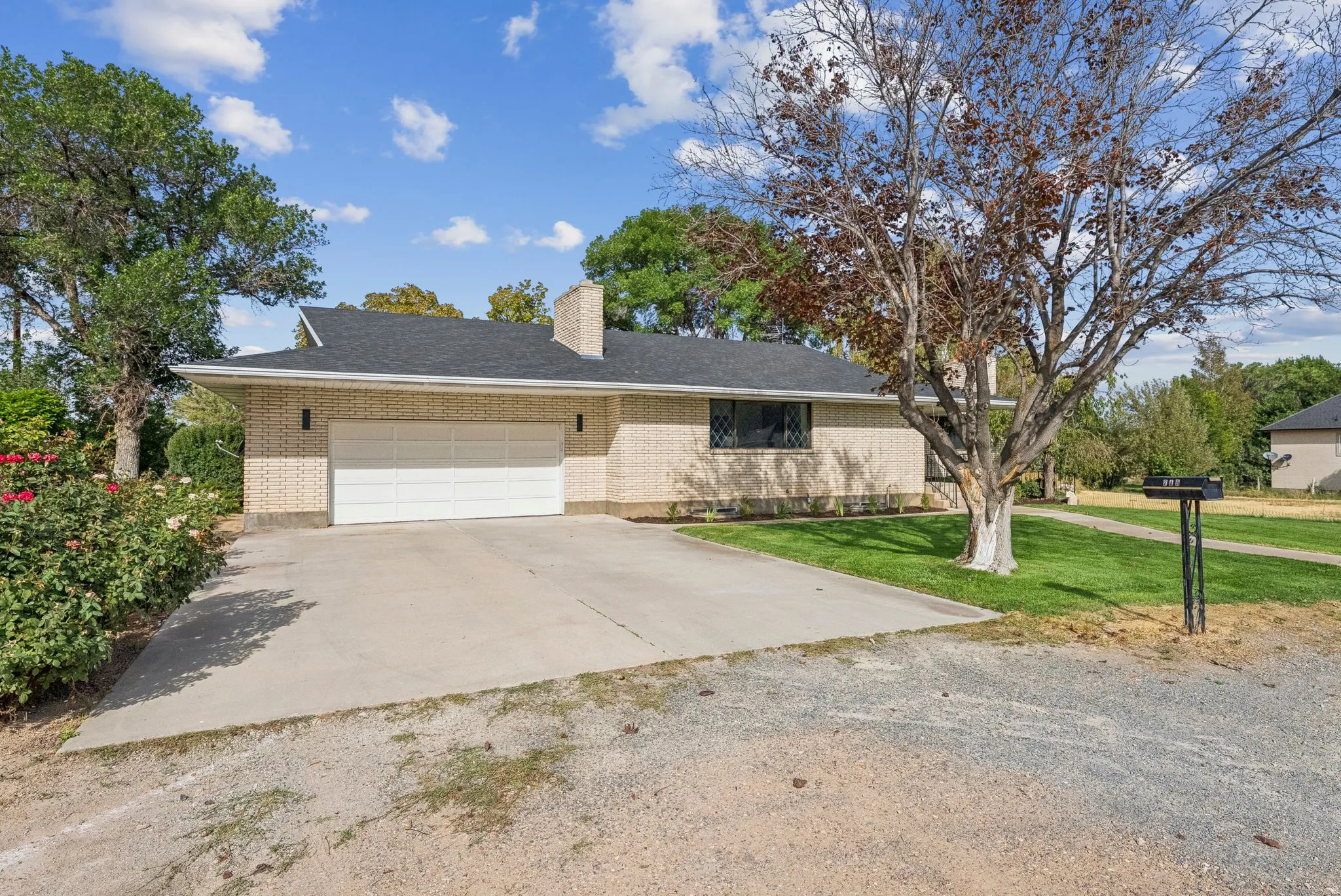 Ranch-style house featuring brick siding, a garage, concrete driveway, and a front yard