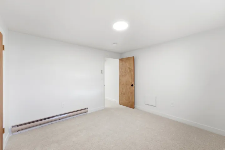 Room with light beige carpet flooring and white walls