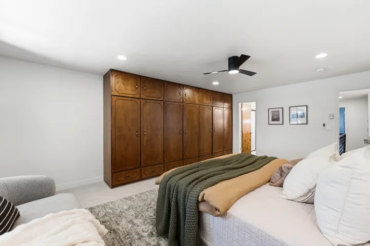 Wall-to-wall built-in wood cabinetry with integrated drawers, ceiling fan with light fixture, recessed ceiling lighting, and light-toned wall finishes