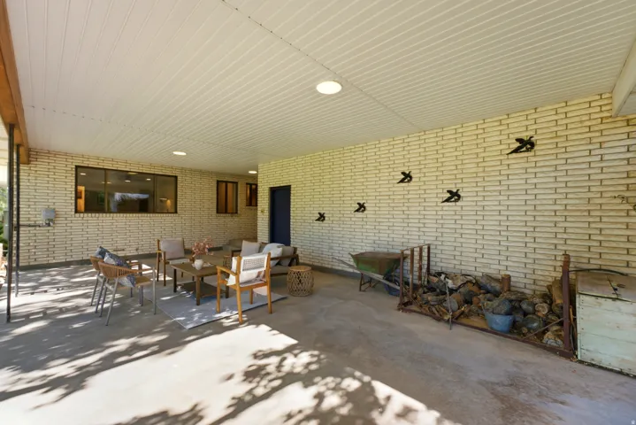 Spacious covered patio featuring brick walls, recessed lighting, and a concrete floor