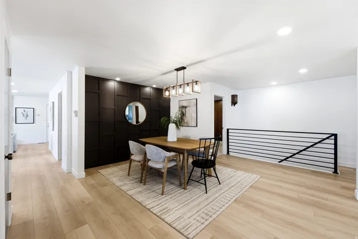Dining area featuring a contemporary linear chandelier, recessed lighting, and wood-finish flooring