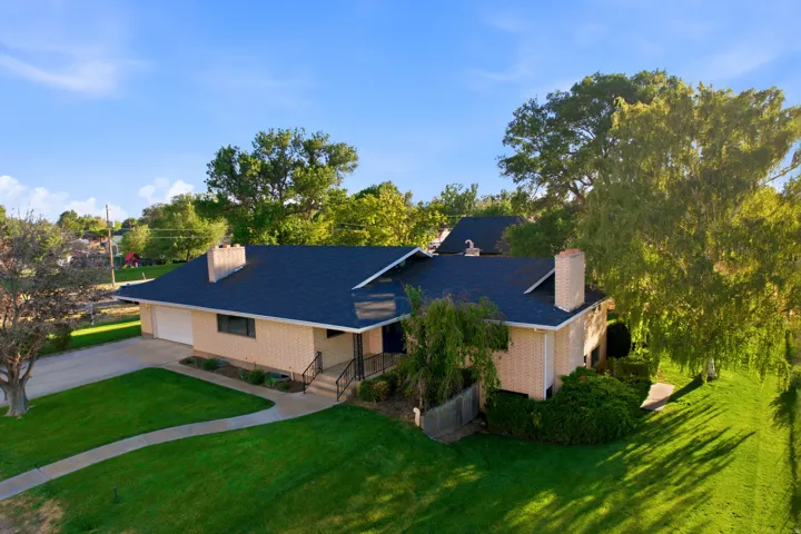 Single-story residence featuring light-colored brick exterior and a dark shingle roof
