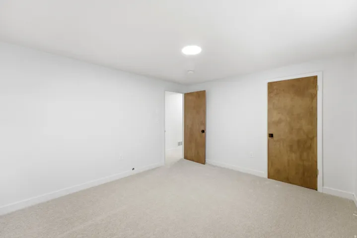 Carpeted interior space with white walls and baseboards