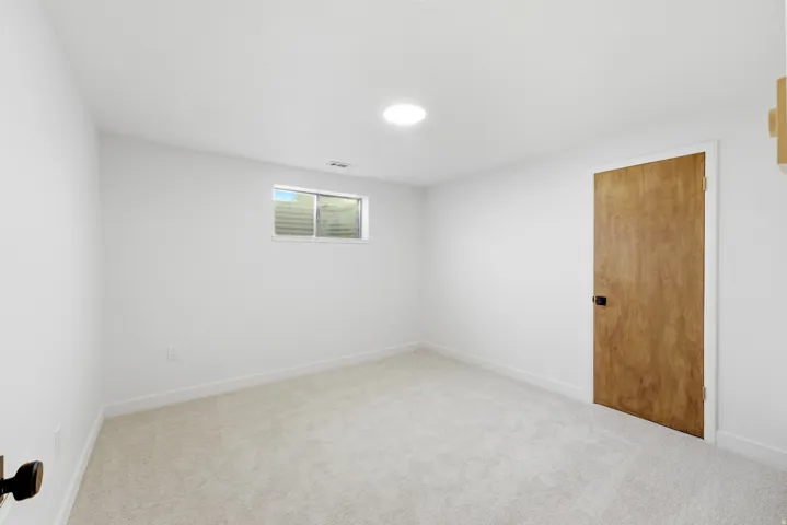 Room featuring light gray carpeting, crisp white walls, and a recessed ceiling light