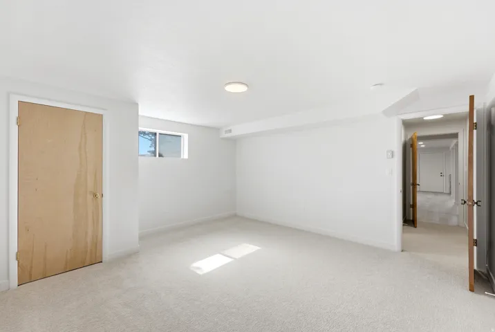 Bright room featuring neutral carpeting and white walls