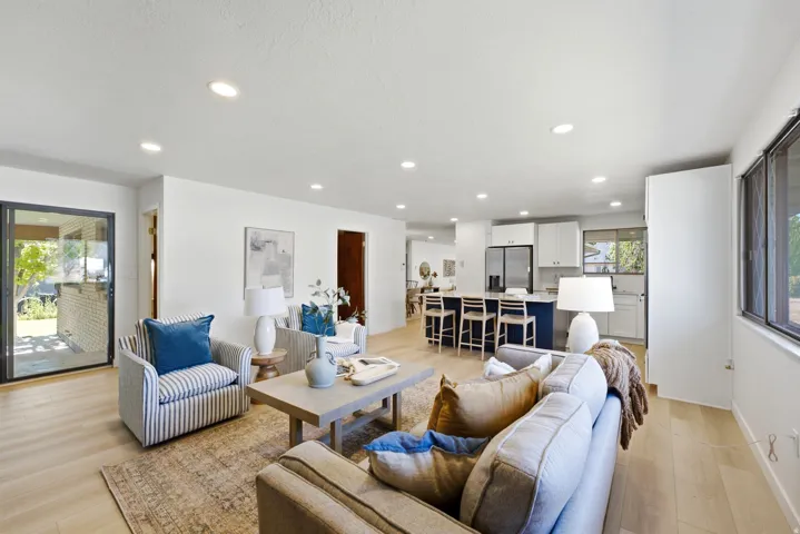 Open-concept living area featuring light wood-finish flooring, recessed lighting, and a neutral color palette