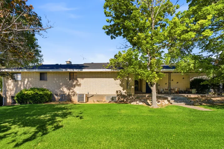 Expansive lawn area with mature trees and a brick-faced exterior