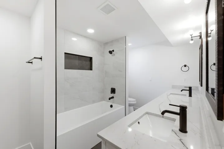 Contemporary bathroom featuring a dual vanity with undermount sinks and matte black fixtures