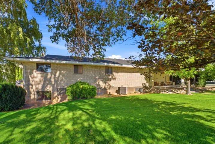 Expansive green lawn with mature trees providing shade