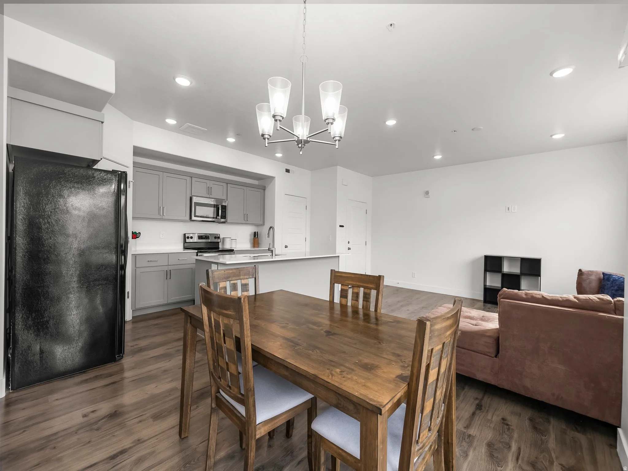 Dining room featuring suspended lighting and dark wood-style flooring