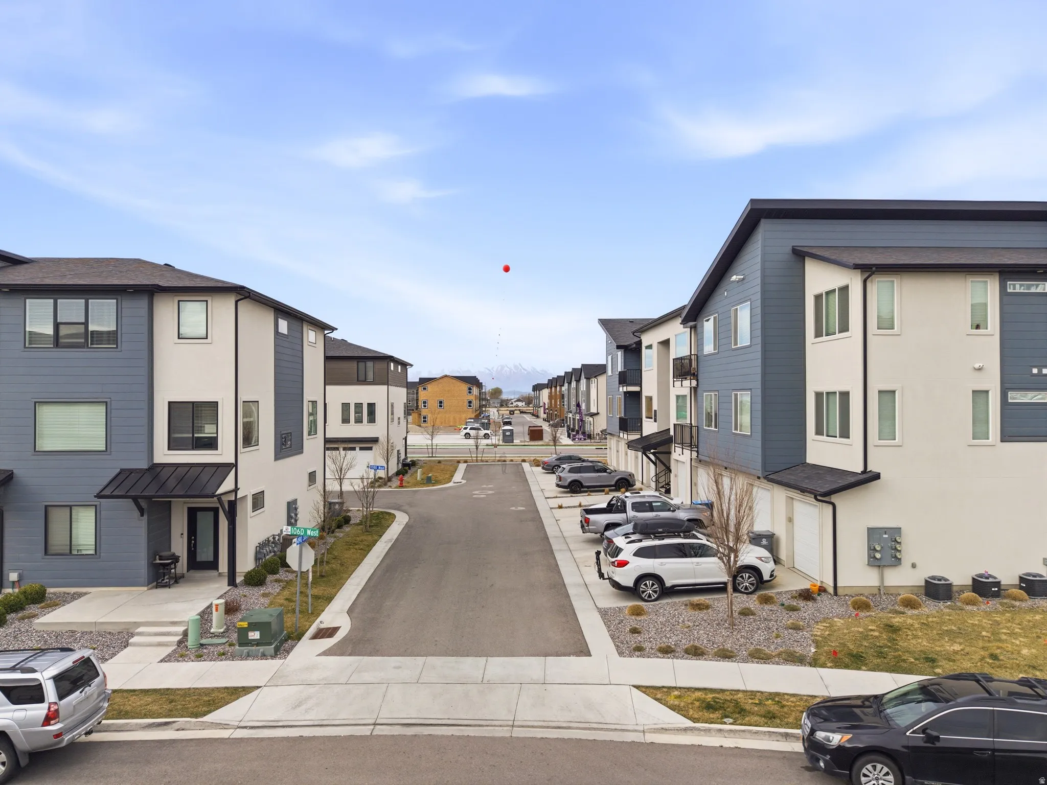 View of asphalt street with a residential view, sidewalks, curbs, and traffic signs