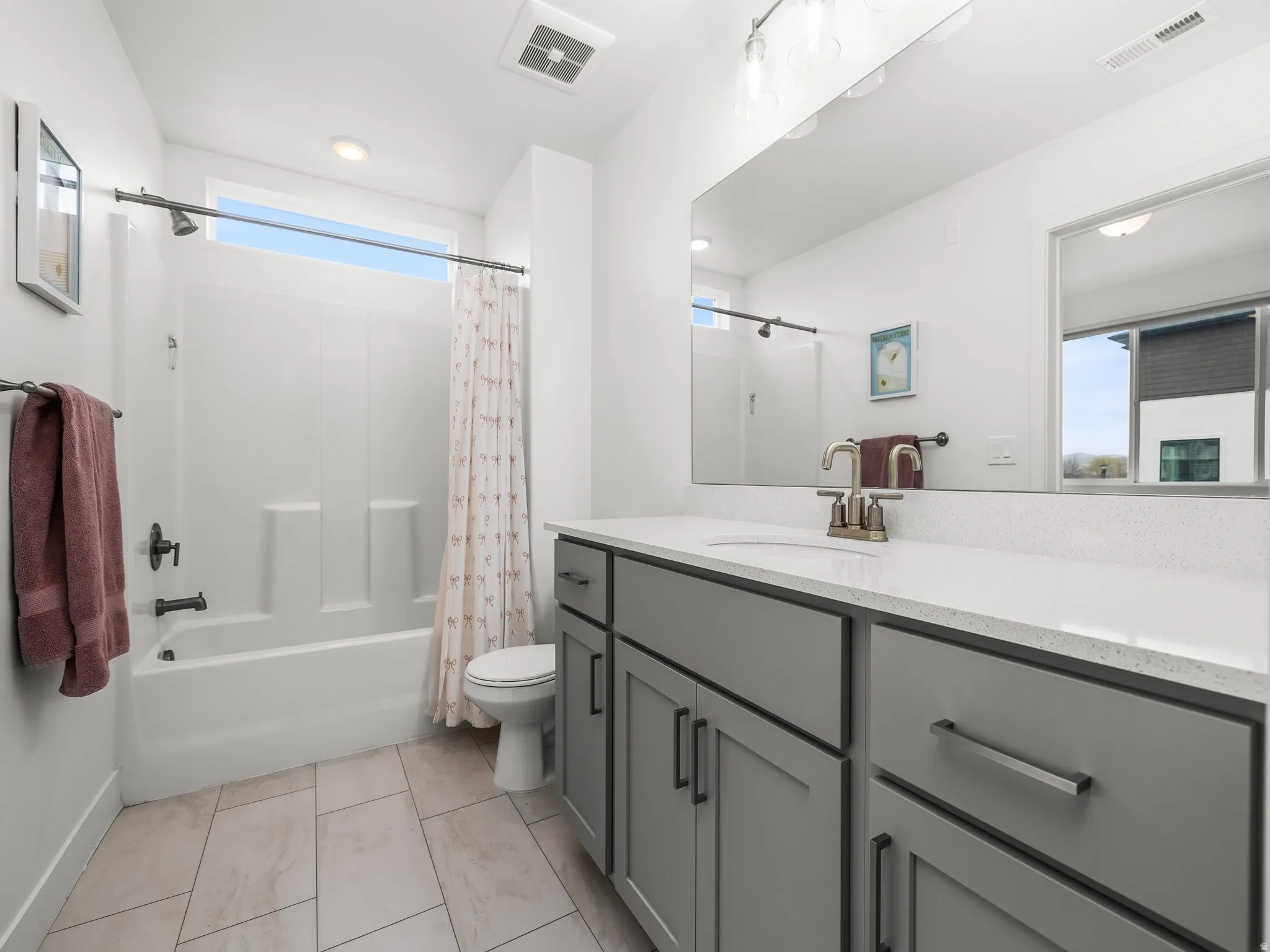 Full bathroom featuring plenty of natural light, vanity, and shower / tub combo