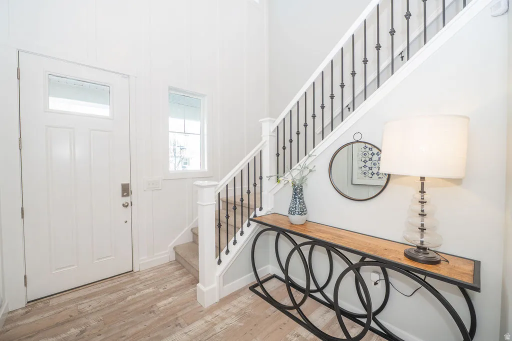 Foyer entrance with stairs and light wood-style floors