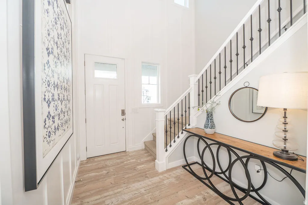Foyer entrance featuring light wood-style flooring and a high ceiling