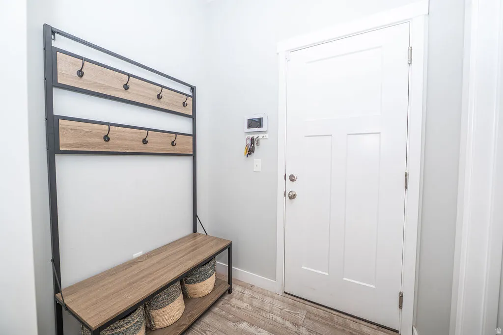 Mudroom with light wood-type flooring and baseboards