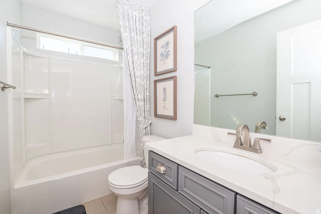 Bathroom with vanity, shower / bath combo, and light tile patterned floors
