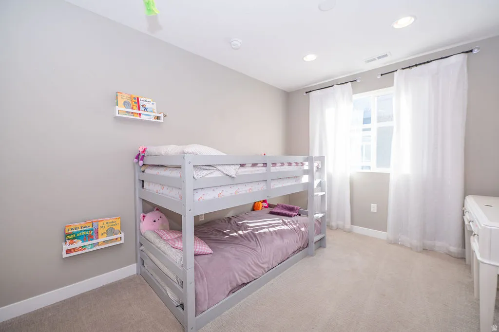Bedroom featuring light colored carpet and recessed lighting
