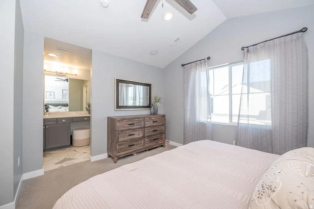 Bedroom with vaulted ceiling, light colored carpet, ceiling fan, recessed lighting, and multiple windows