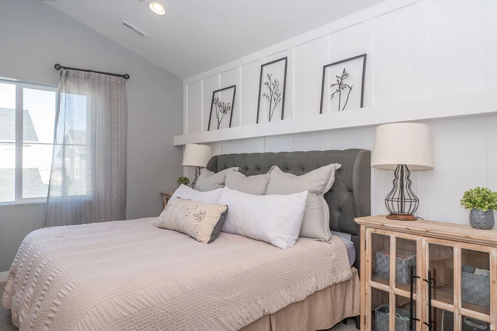 Bedroom with vaulted ceiling and recessed lighting