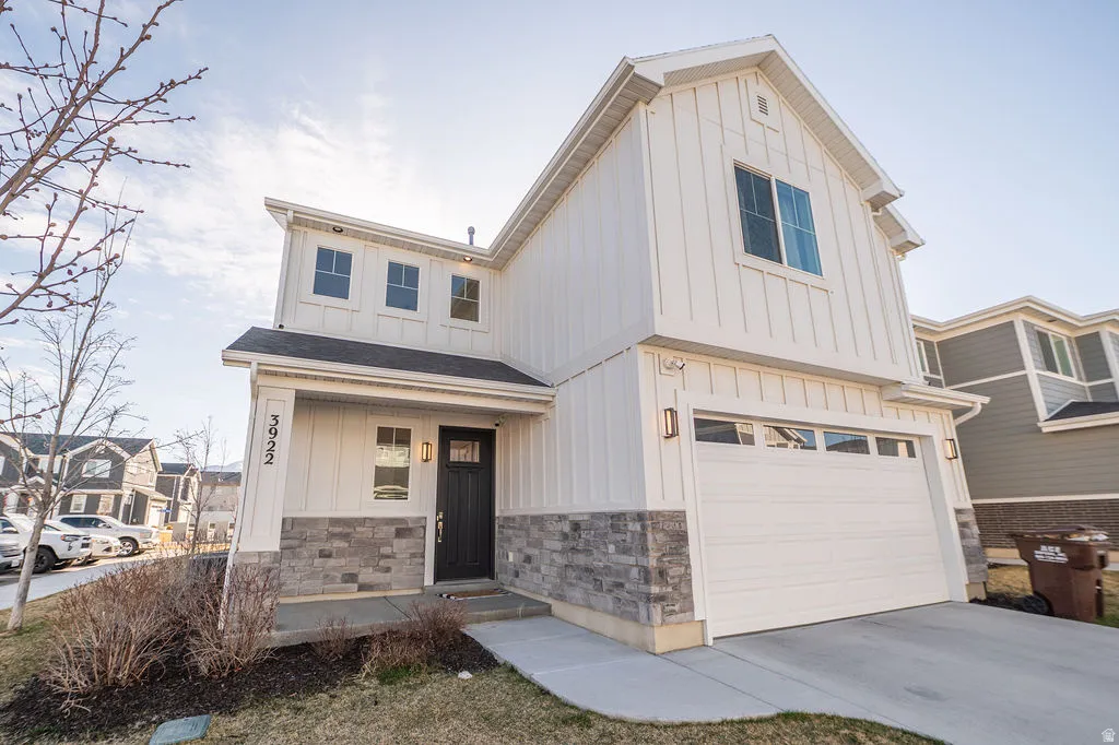 Modern farmhouse style home with board and batten siding, an attached garage, concrete driveway, and covered porch