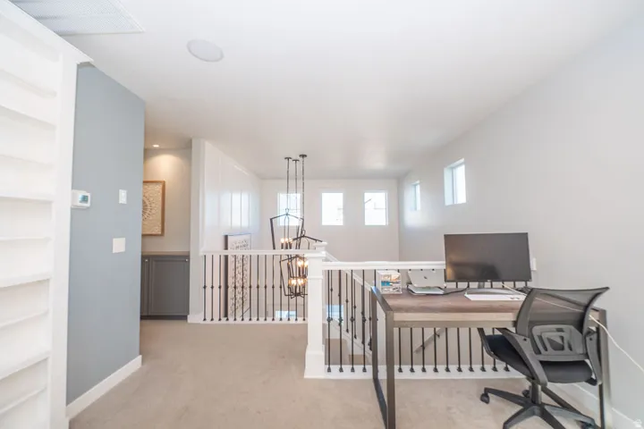 Office area with light carpet and a chandelier