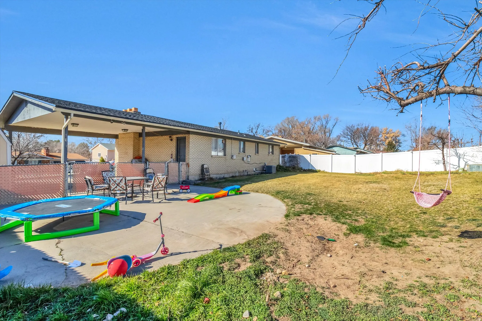 Rear view of house featuring a fenced backyard, a patio area, and brick siding