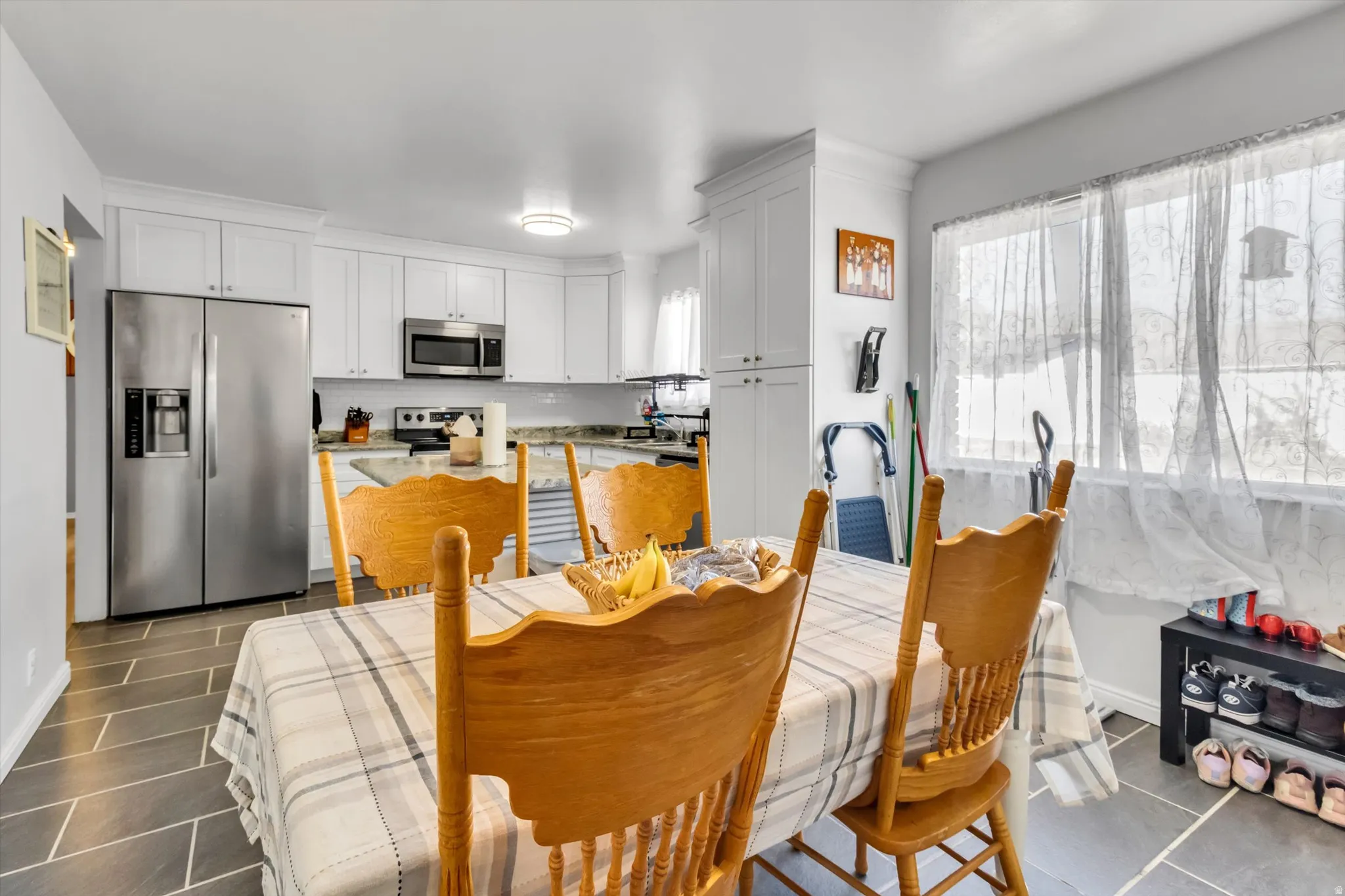 Dining area featuring baseboards and dark tile patterned floors