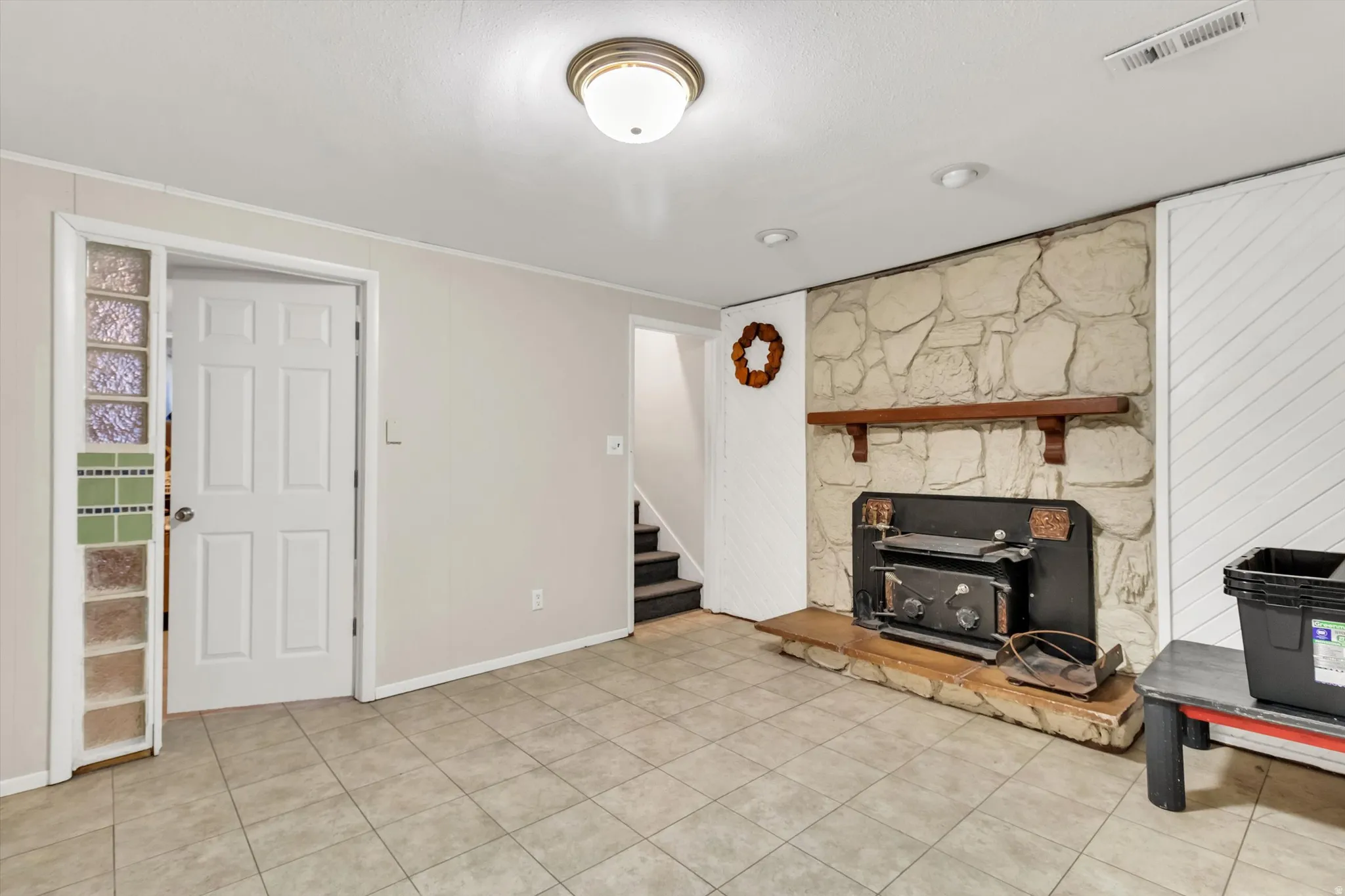 Unfurnished living room with stairway and light tile patterned floors