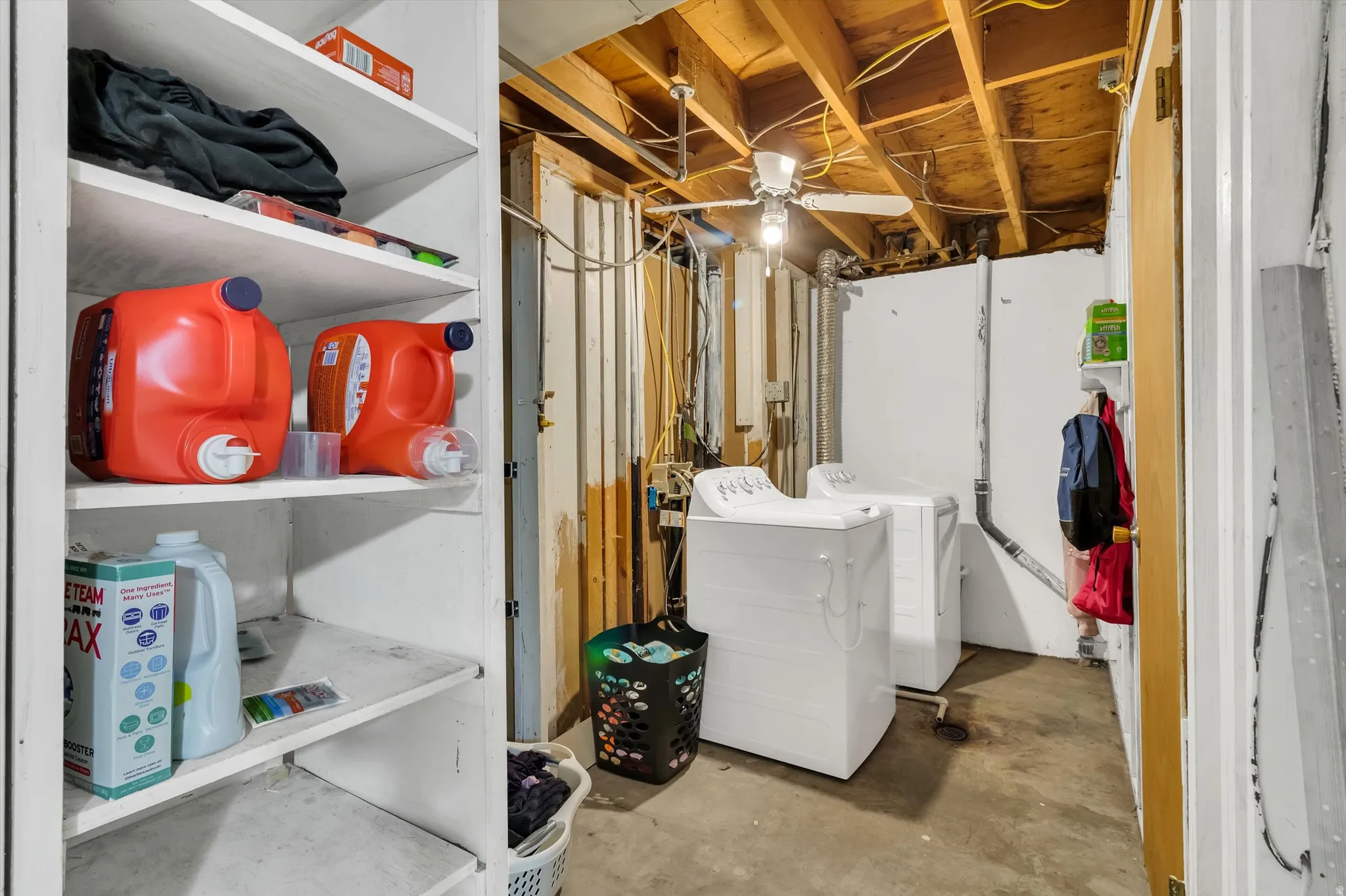 Laundry area with independent washer and dryer and unfinished concrete flooring