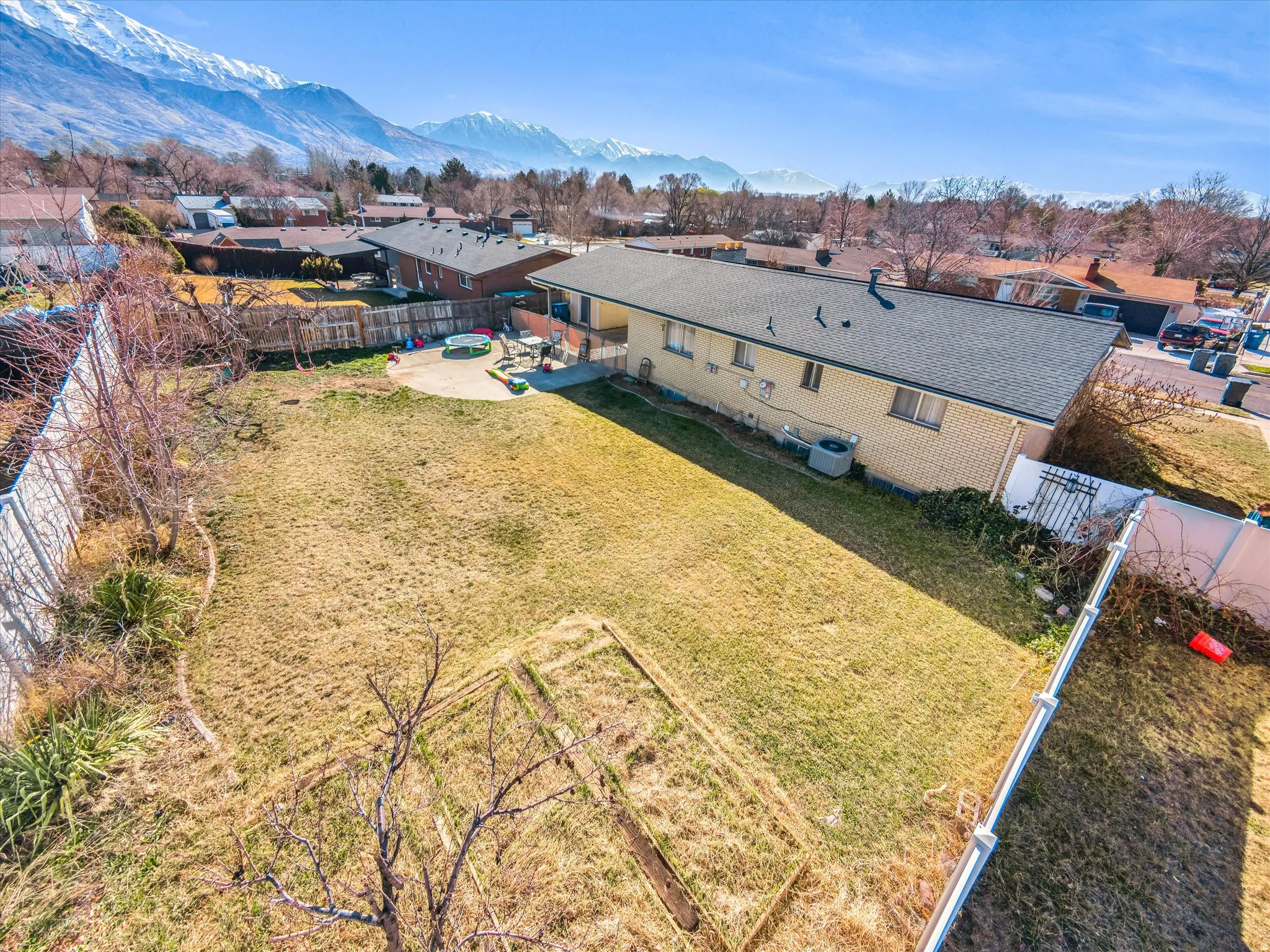 Expansive backyard featuring a large grass area and a concrete patio