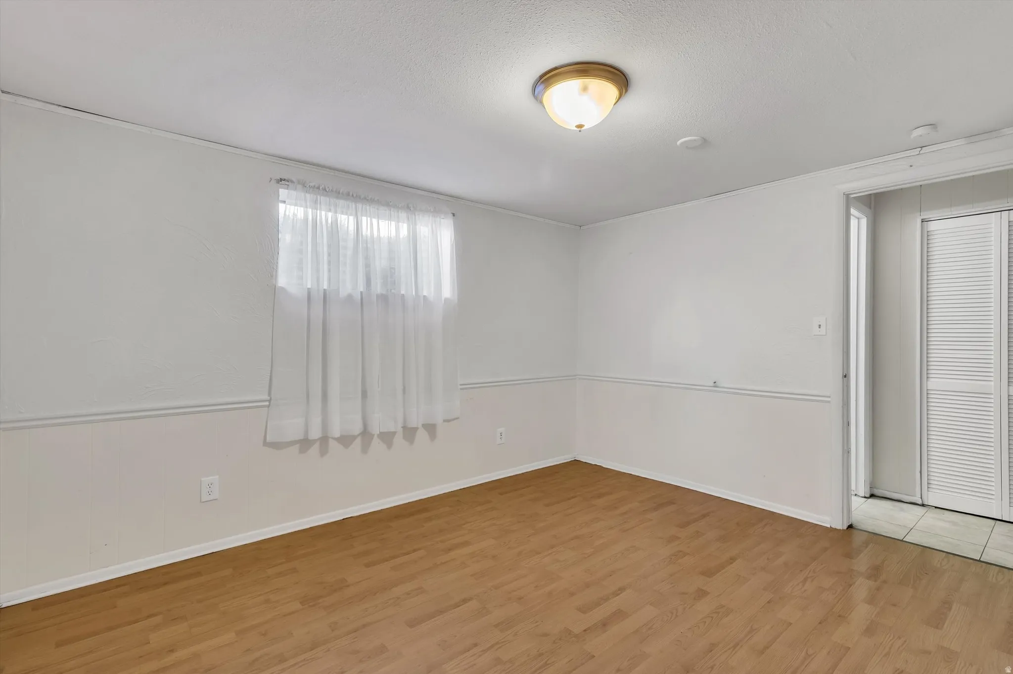 Empty room with light wood finished floors and baseboards