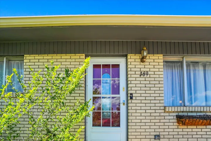 Front exterior featuring light-colored brick siding and a white entry door with divided lites