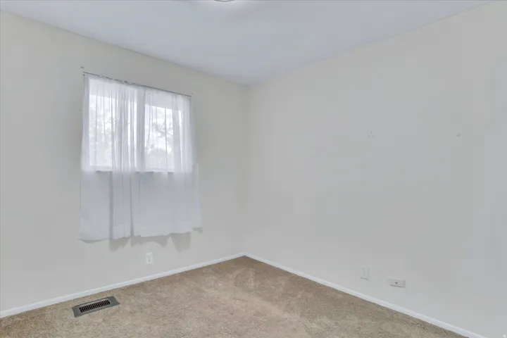 Interior room featuring light-colored walls and neutral carpeting