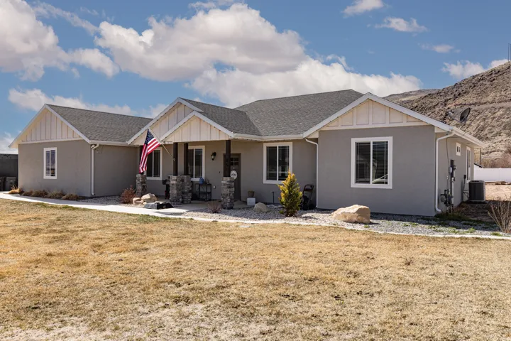 View of front of property featuring board and batten siding, a porch, a shingled roof, and a front lawn