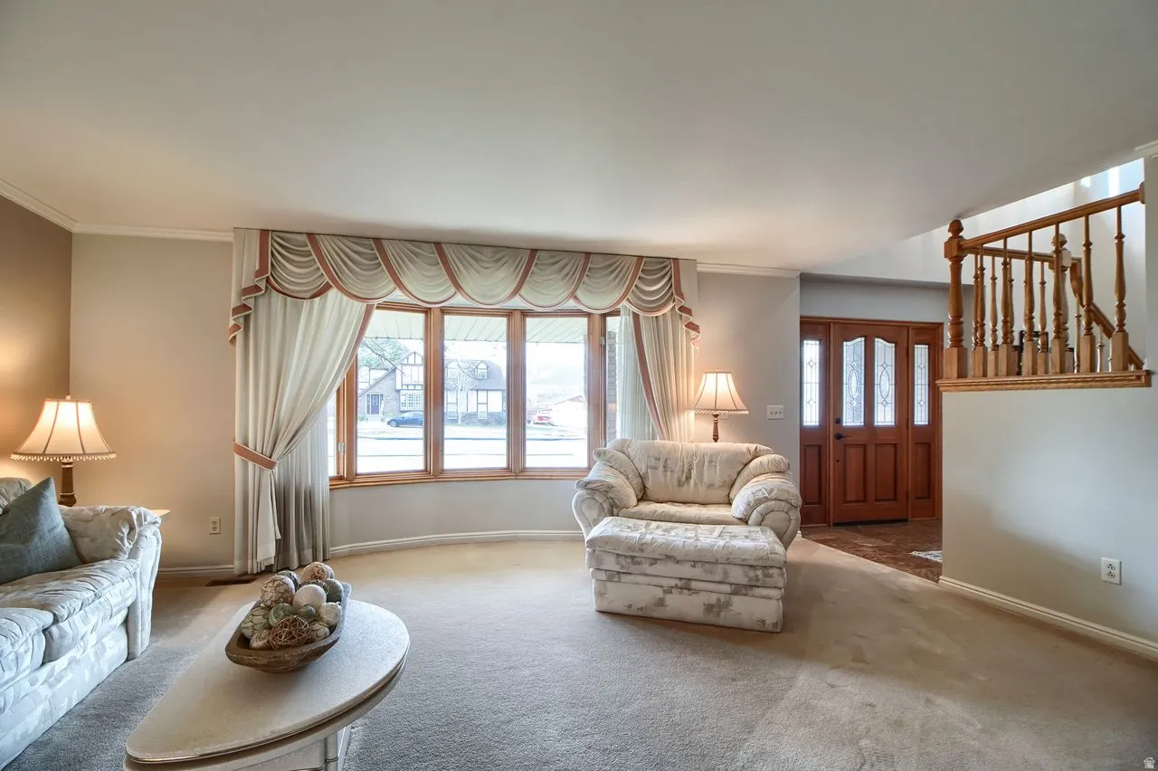 Carpeted living area with ornamental molding