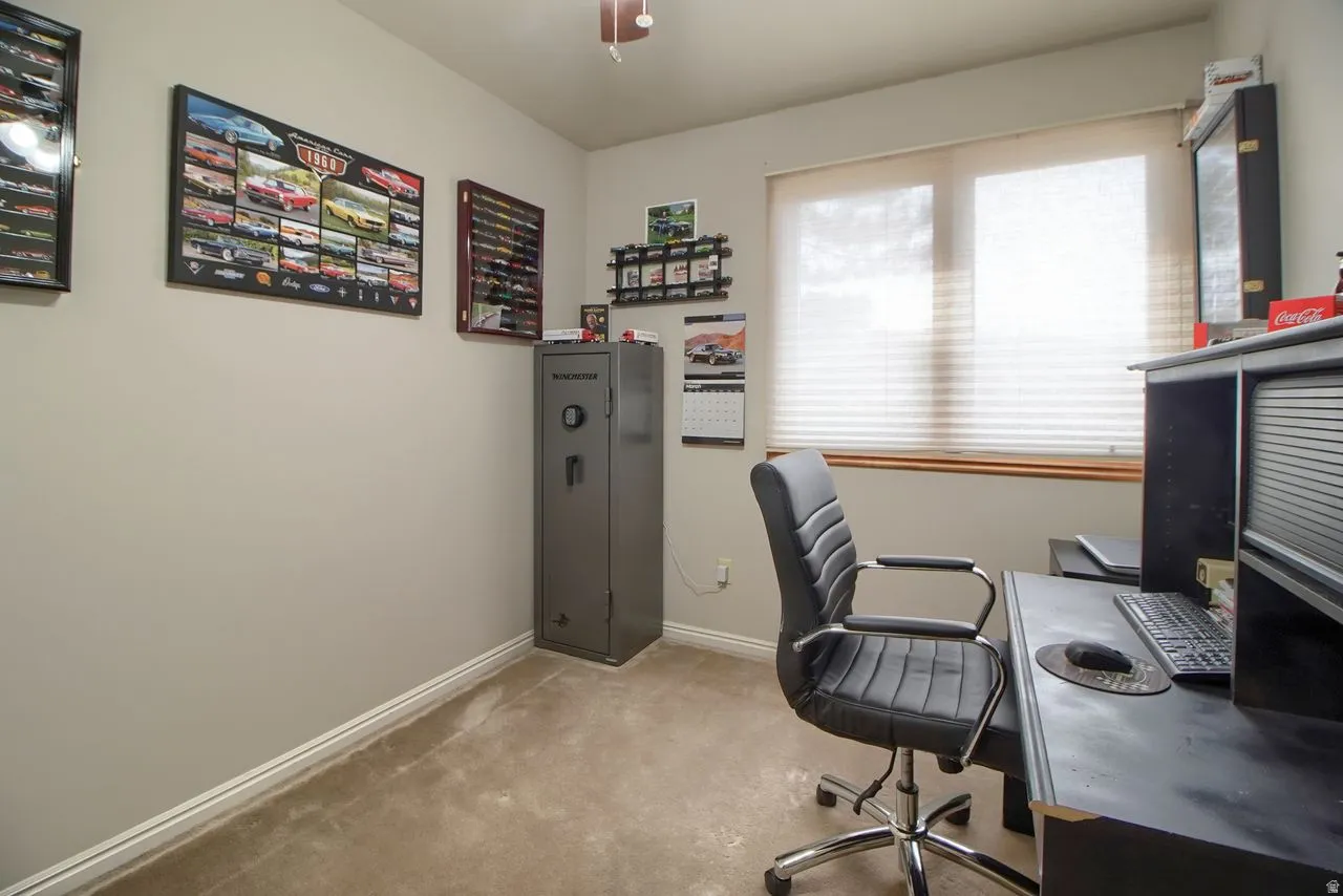 Office space with light colored carpet and a ceiling fan