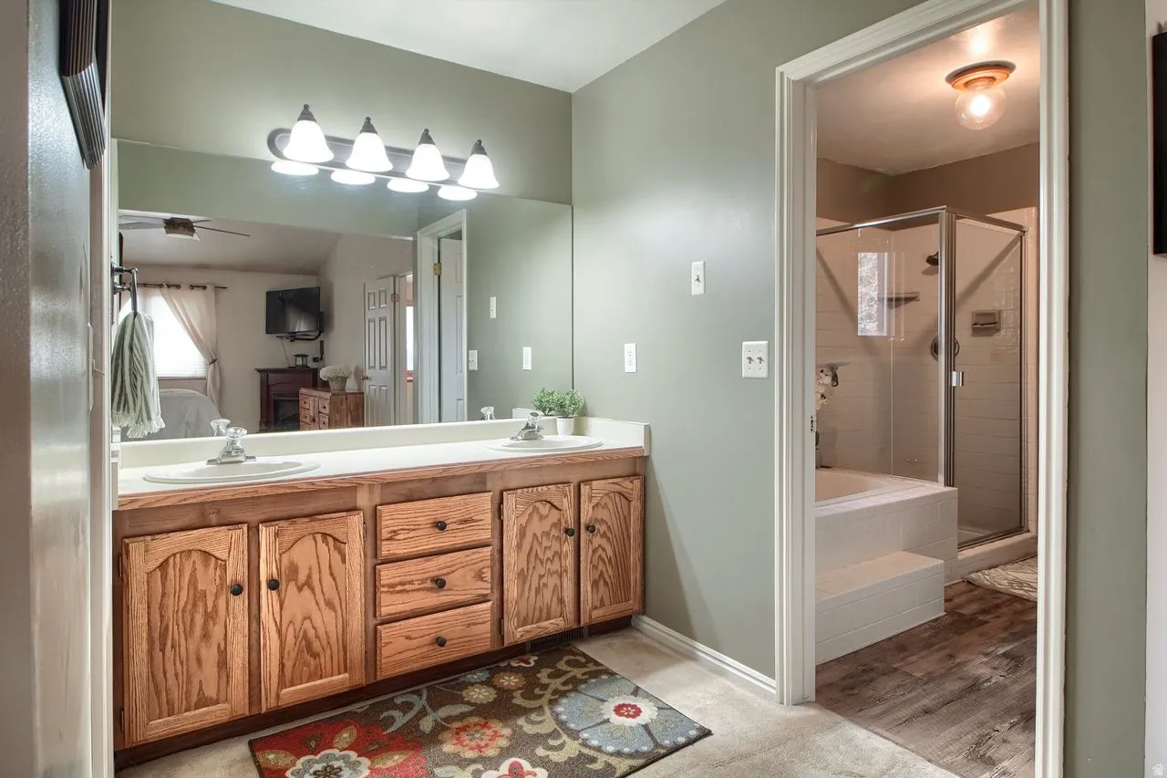 Ensuite bathroom with double vanity, a shower stall, and a garden tub