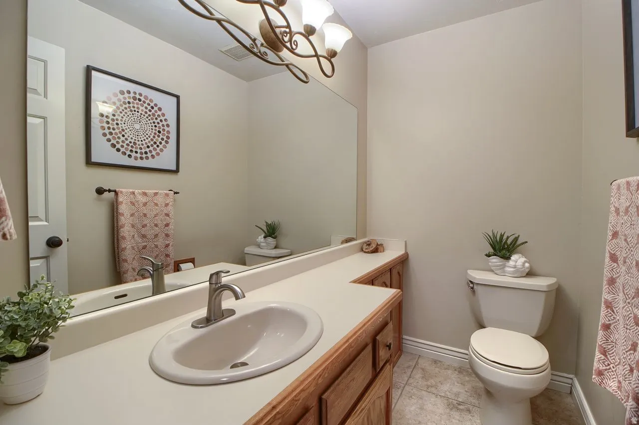 Bathroom featuring vanity, light tile patterned flooring, and hanging lights