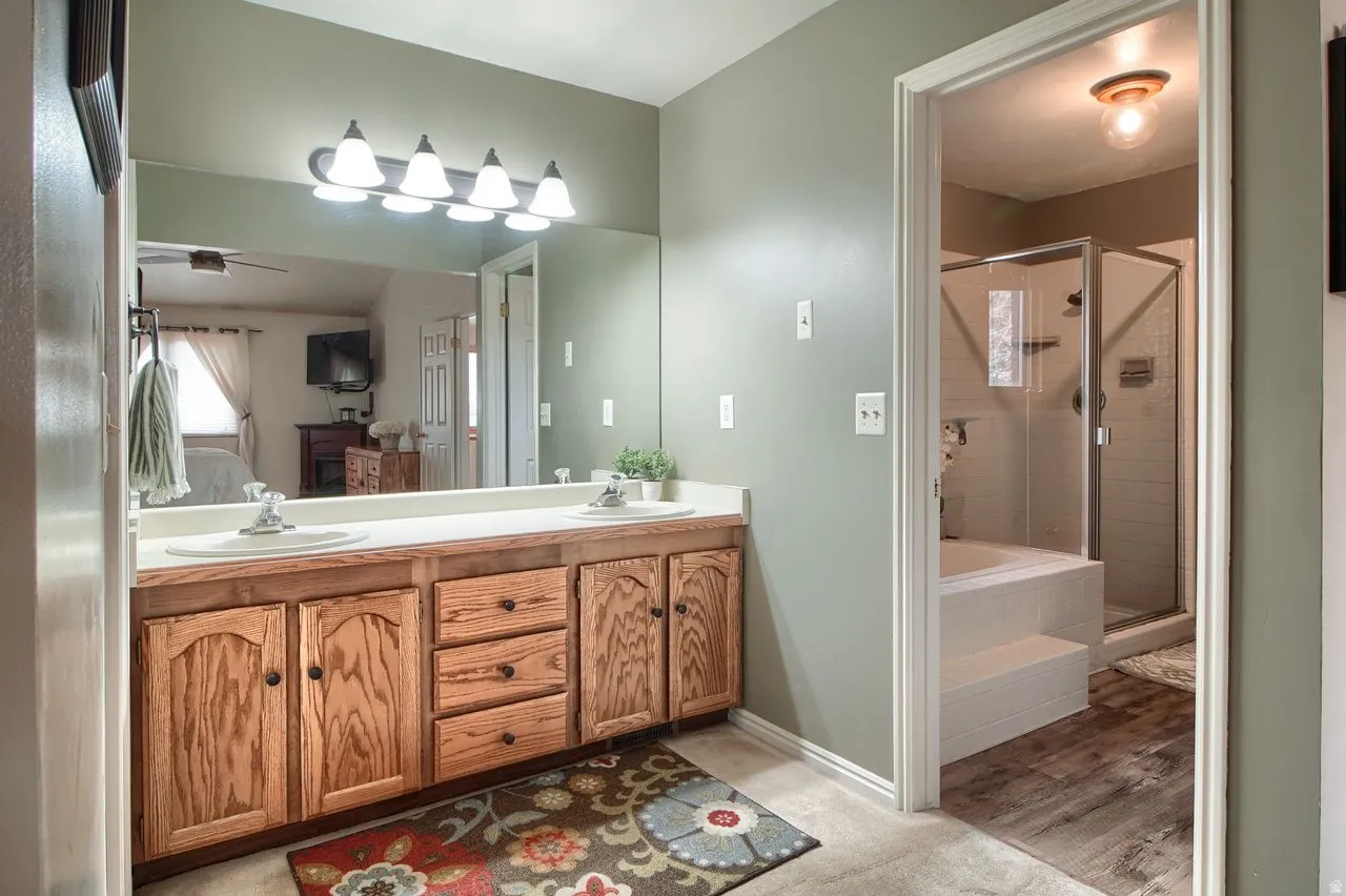 Full bathroom with double vanity, ensuite bathroom, a garden tub, and a shower stall
