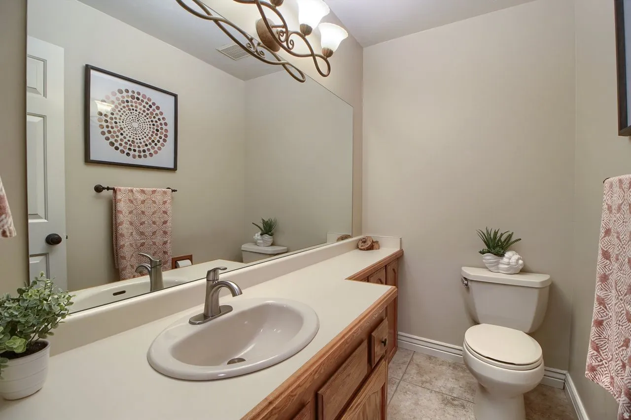 Bathroom featuring vanity, light tile patterned floors, and a chandelier