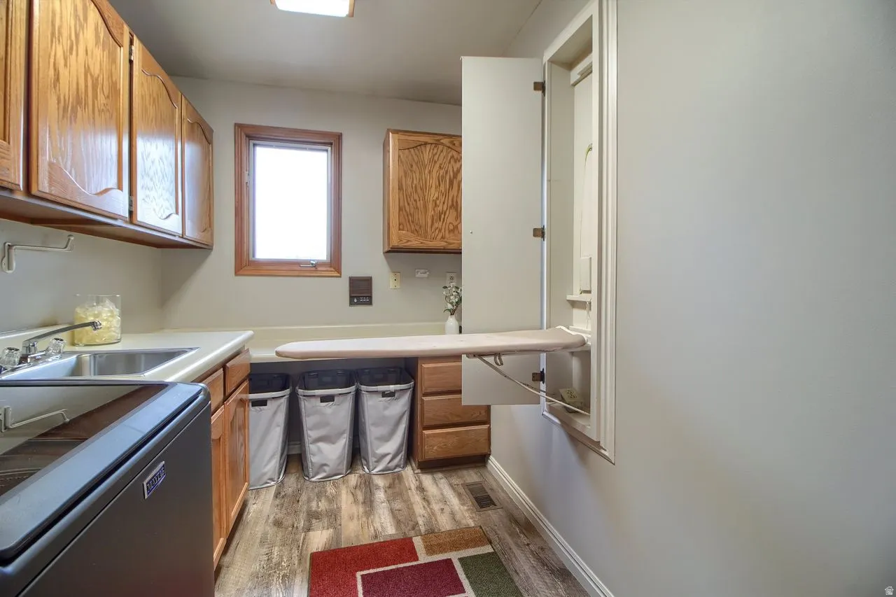 Laundry room with light wood-style flooring and washer / clothes dryer